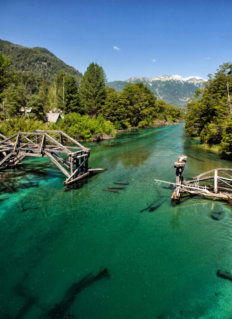 A picturesque broken bridge over a turquoise river in San Martín de los Andes, Argentina.