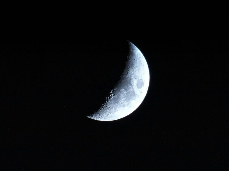 A detailed view of the crescent moon against a dark night sky, showcasing lunar craters.